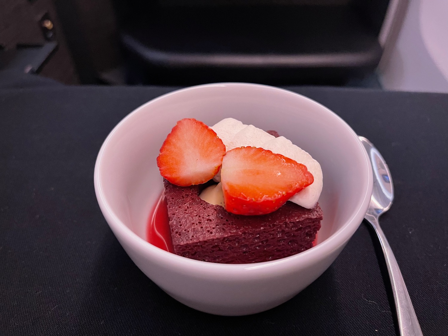 a bowl of dessert with strawberries and cream