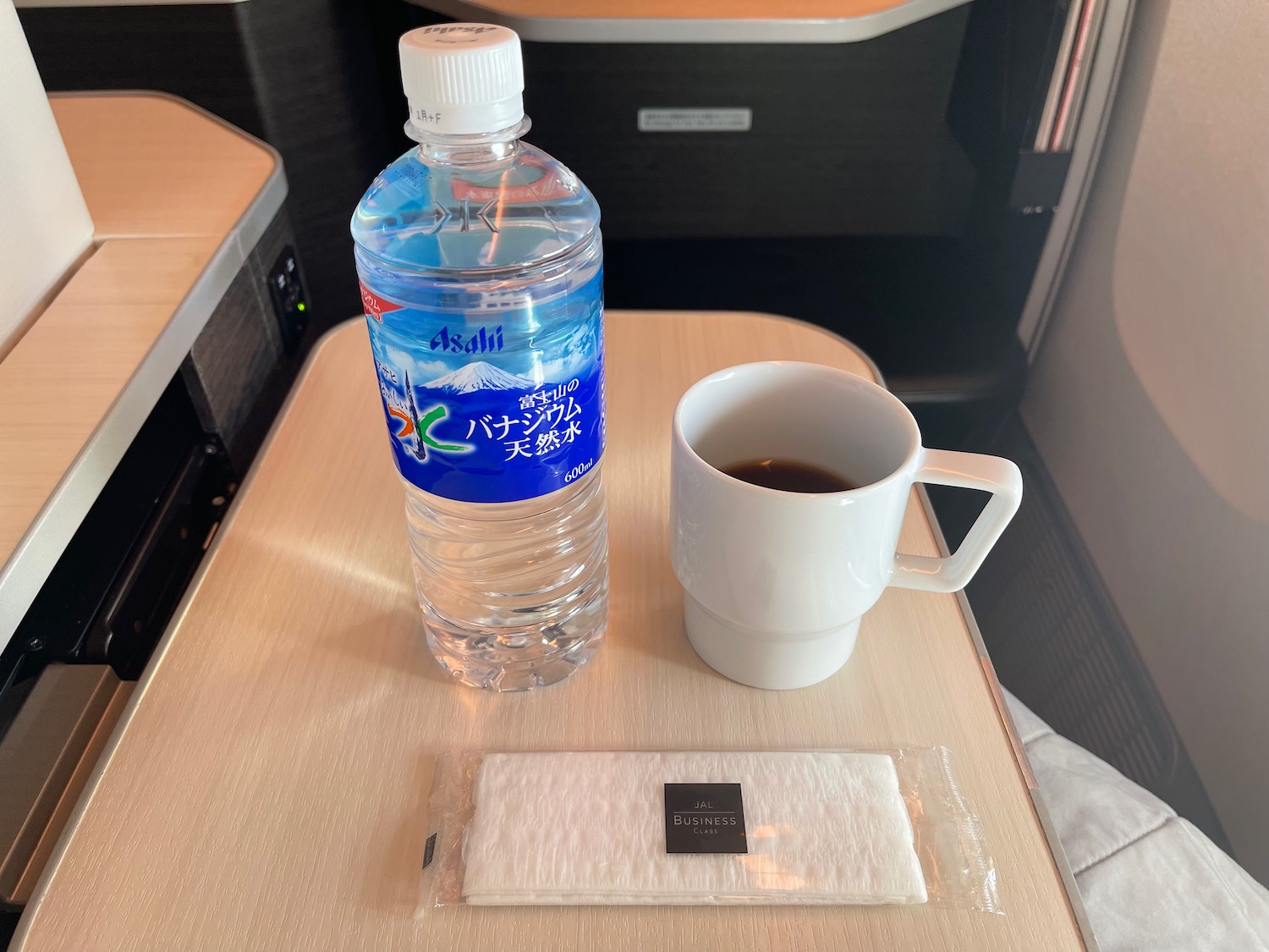 a bottle of water and a cup of coffee on a table