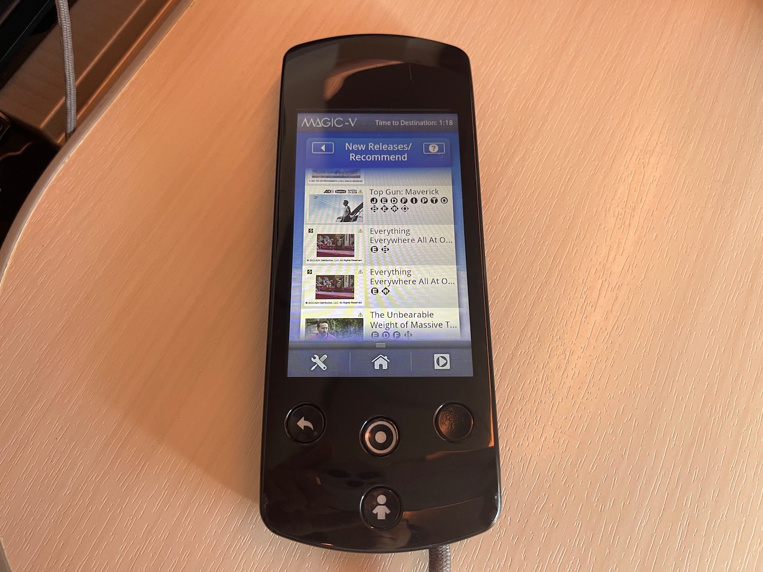 a black rectangular device with a screen on a wooden surface