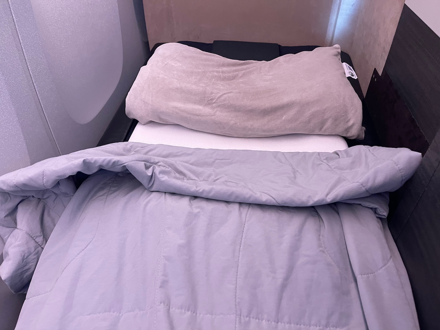 a bed with a pillow and blanket