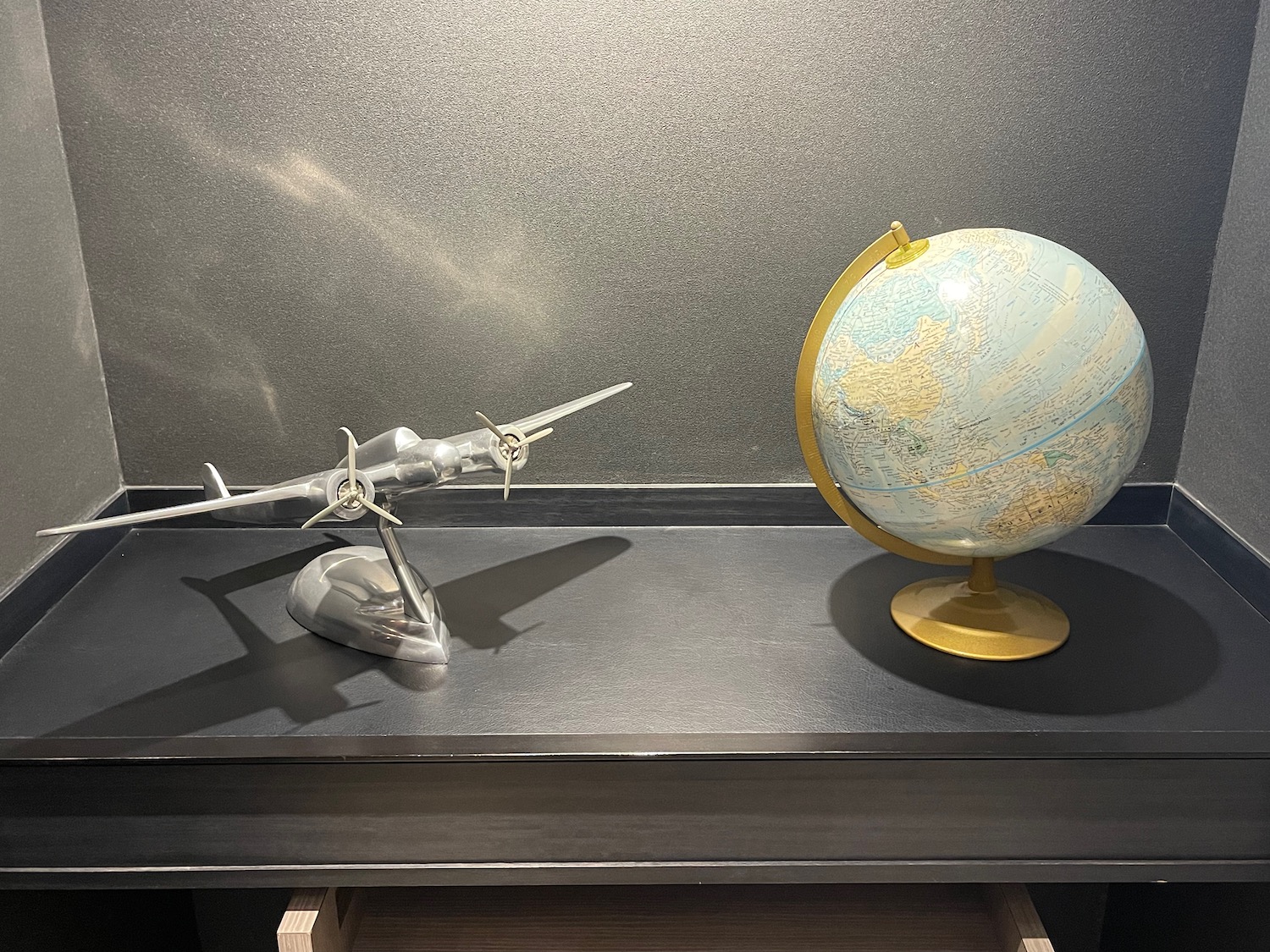 a model airplane and globe on a table