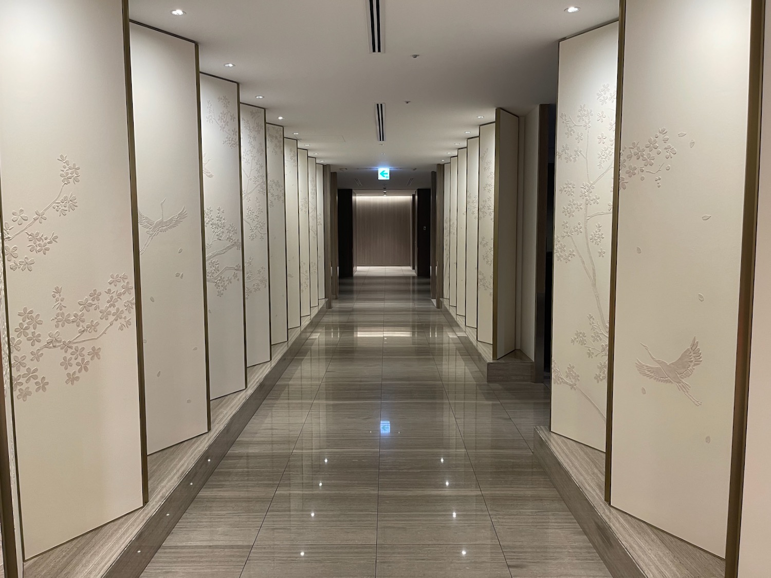 a hallway with white walls and a tile floor