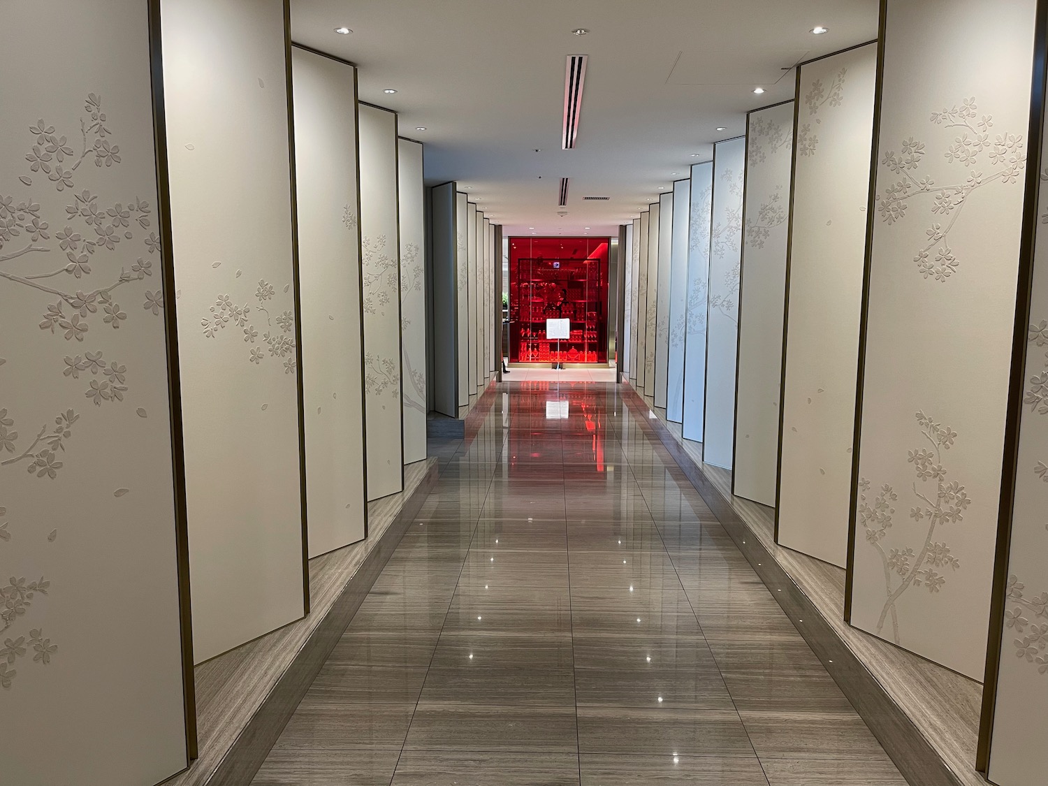 a hallway with white walls and red glass