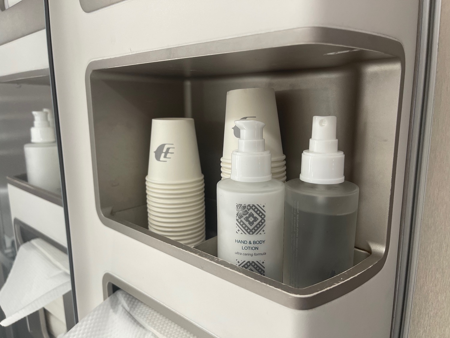 a group of bottles and cups in a shelf