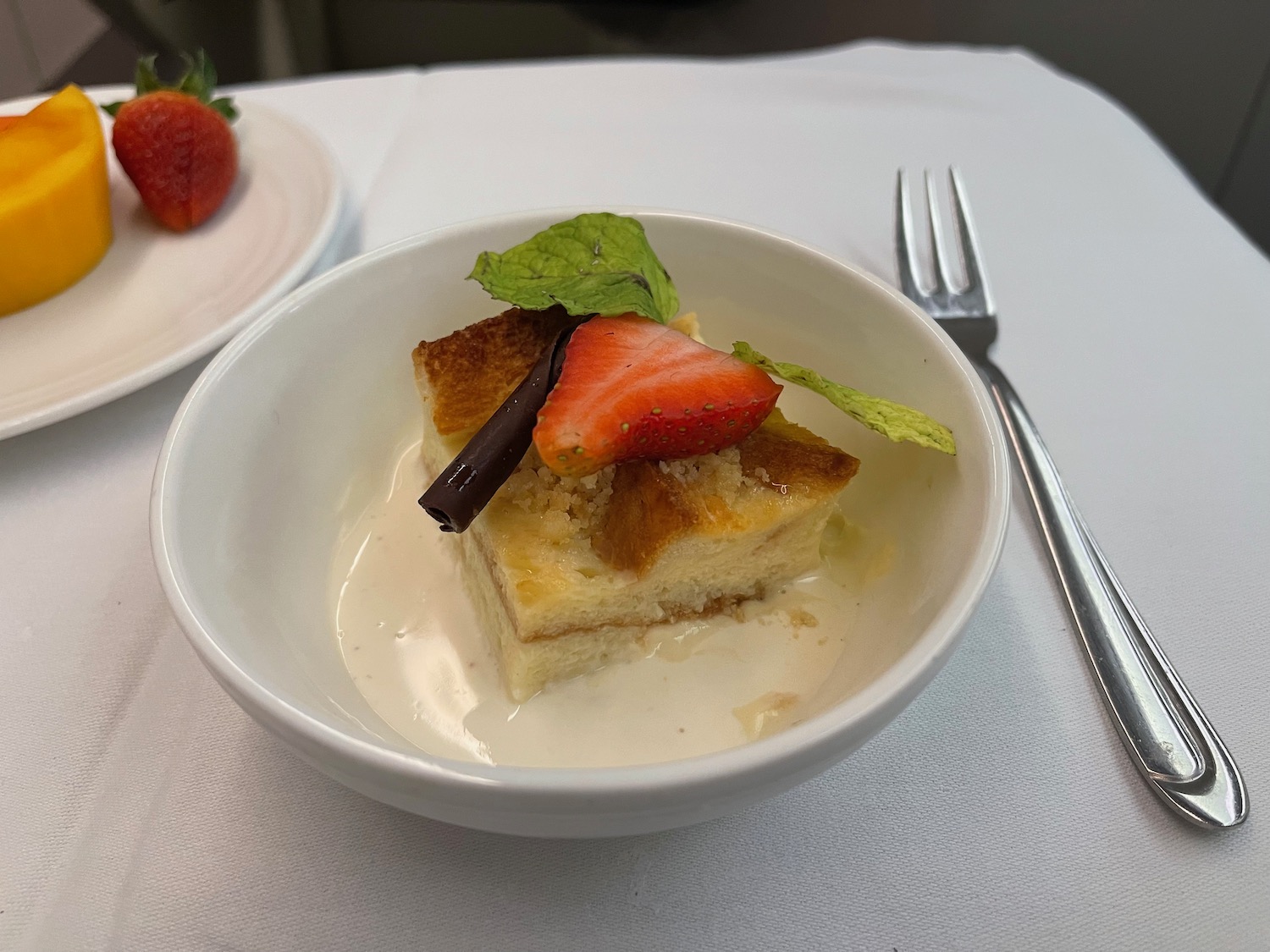 a bowl of dessert with strawberries and a fork