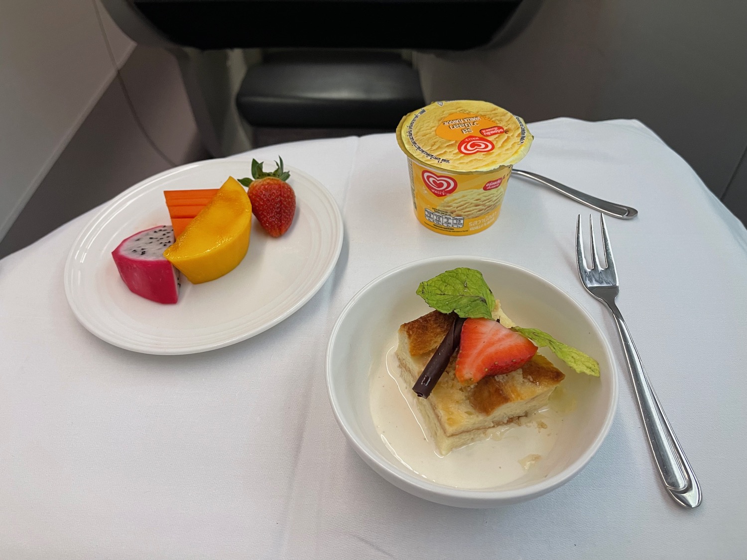 a plate of fruit and dessert on a table