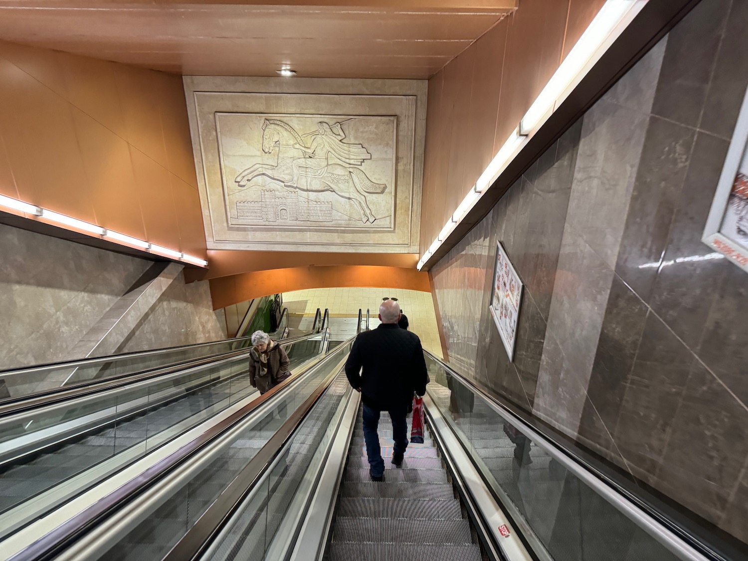 a man and woman on an escalator
