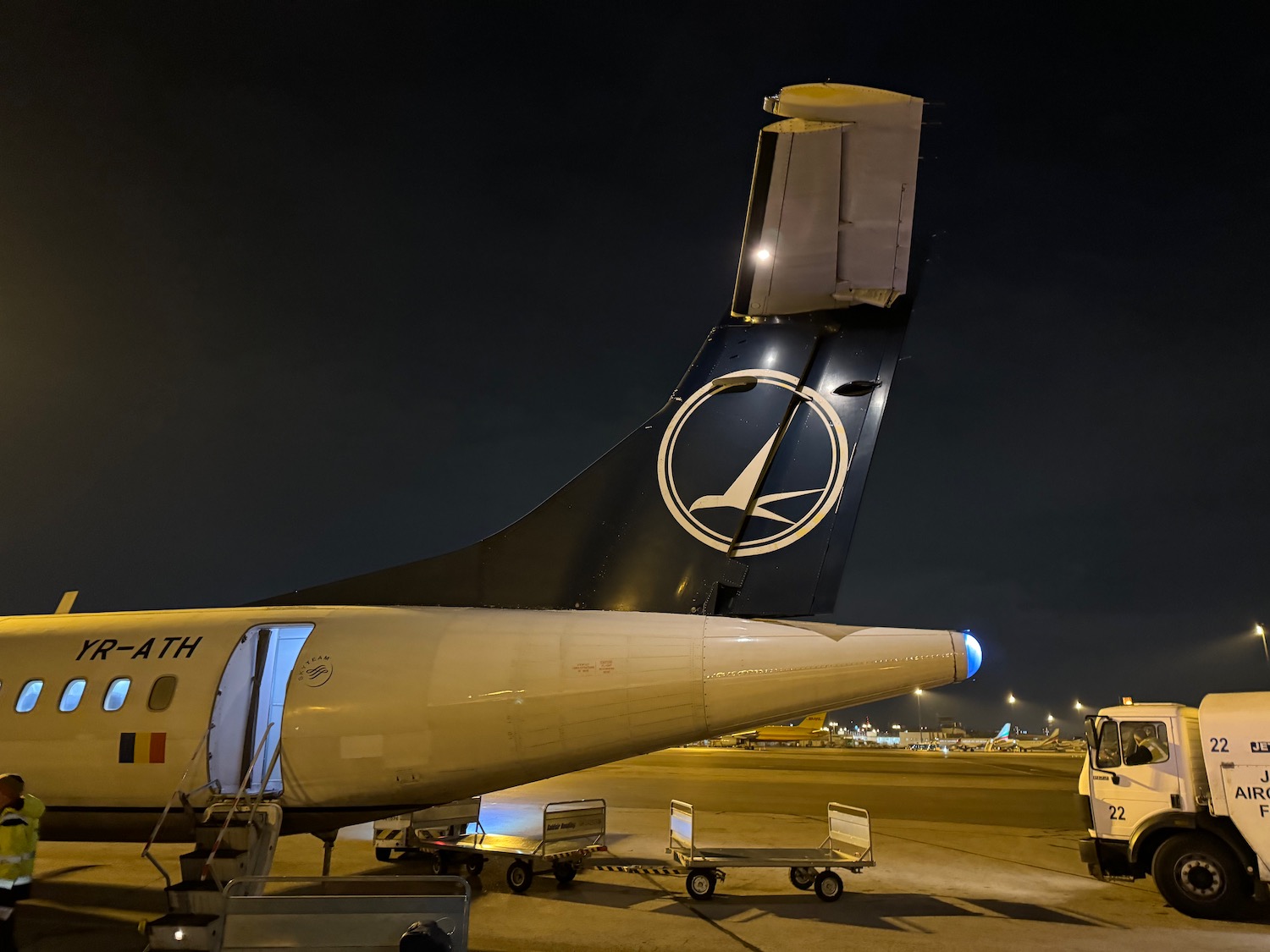 a plane with a tail fin and a truck on the ground