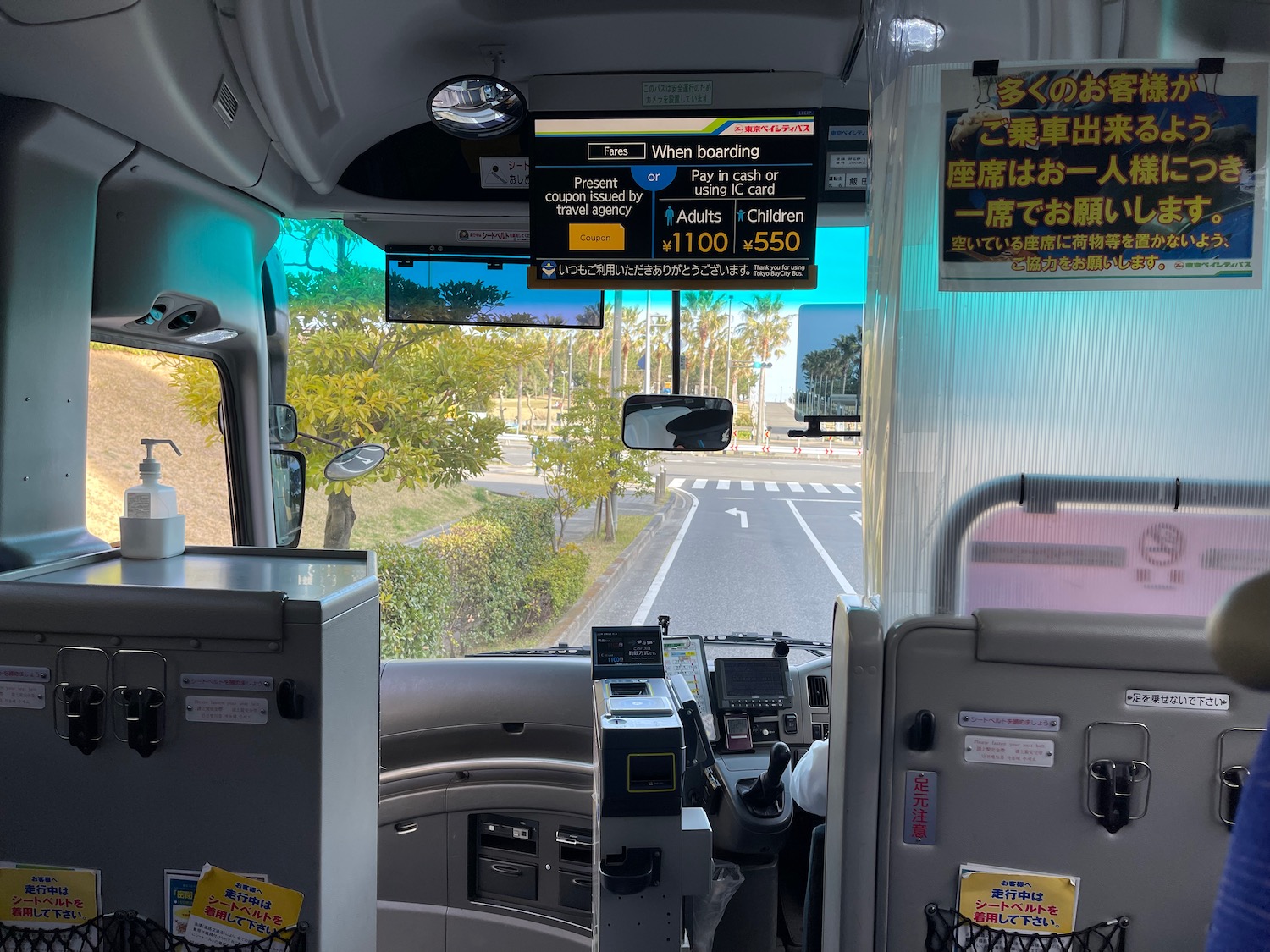 inside a bus with a view of the road and trees