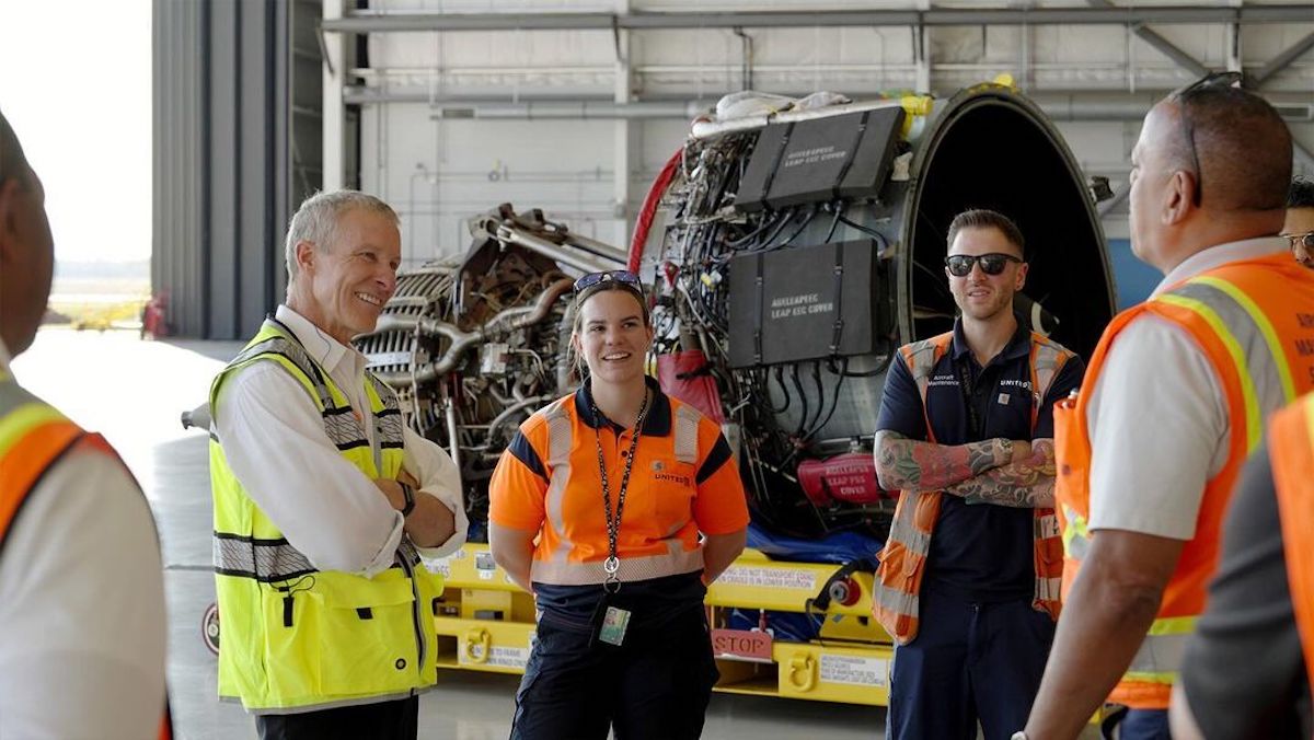 a group of people standing in a hangar