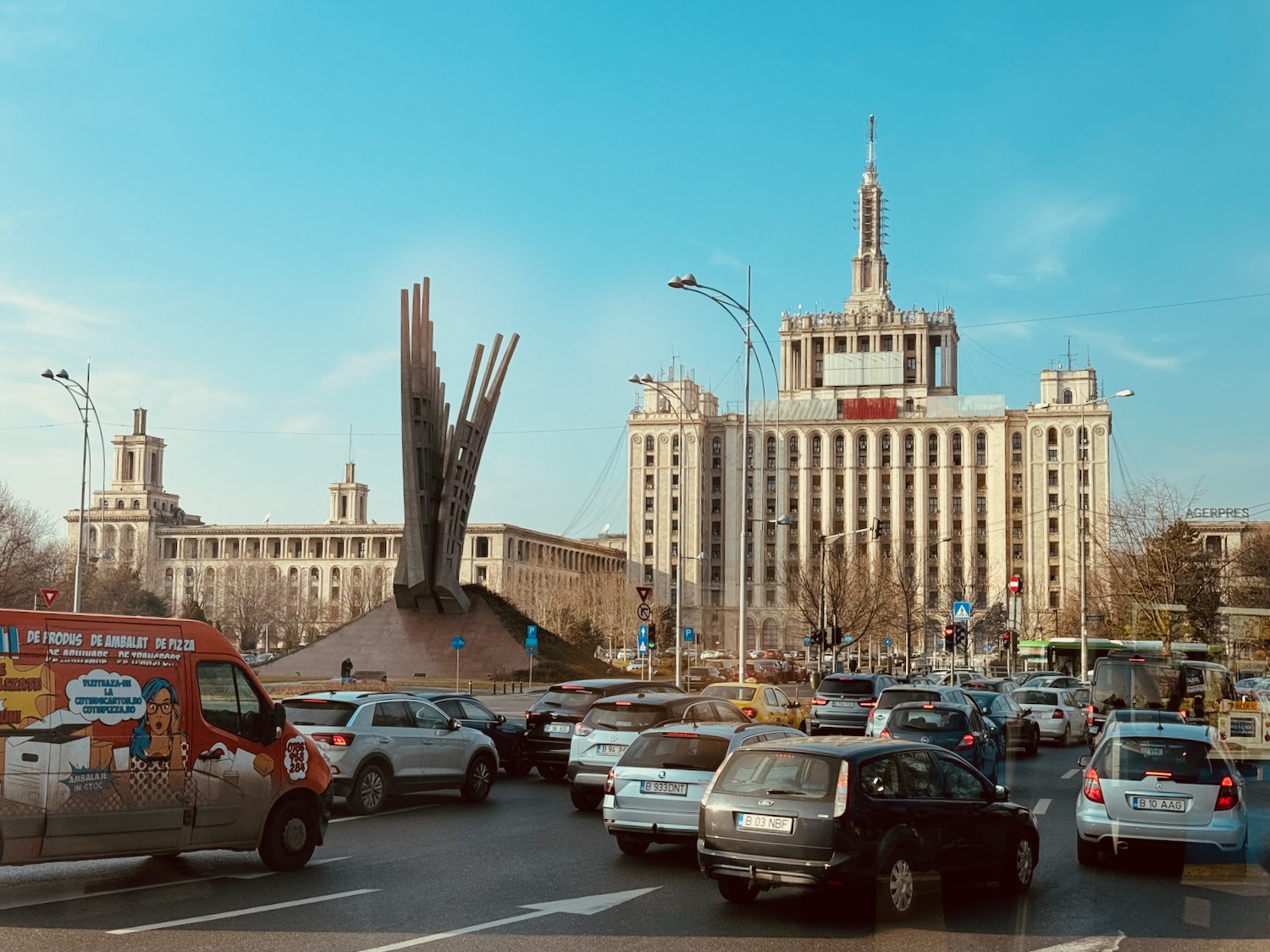 a traffic on a road with a large building in the background