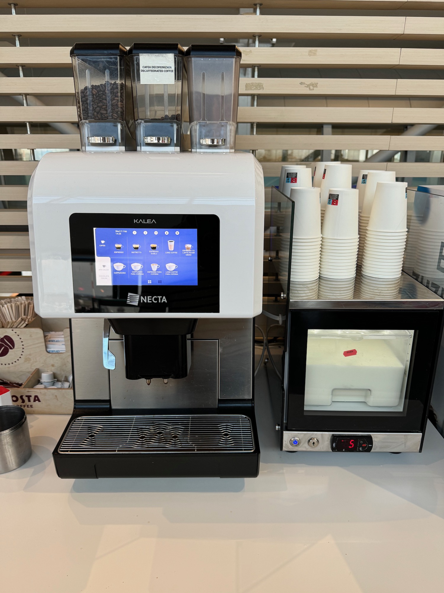 a machine with a screen and cups on a counter