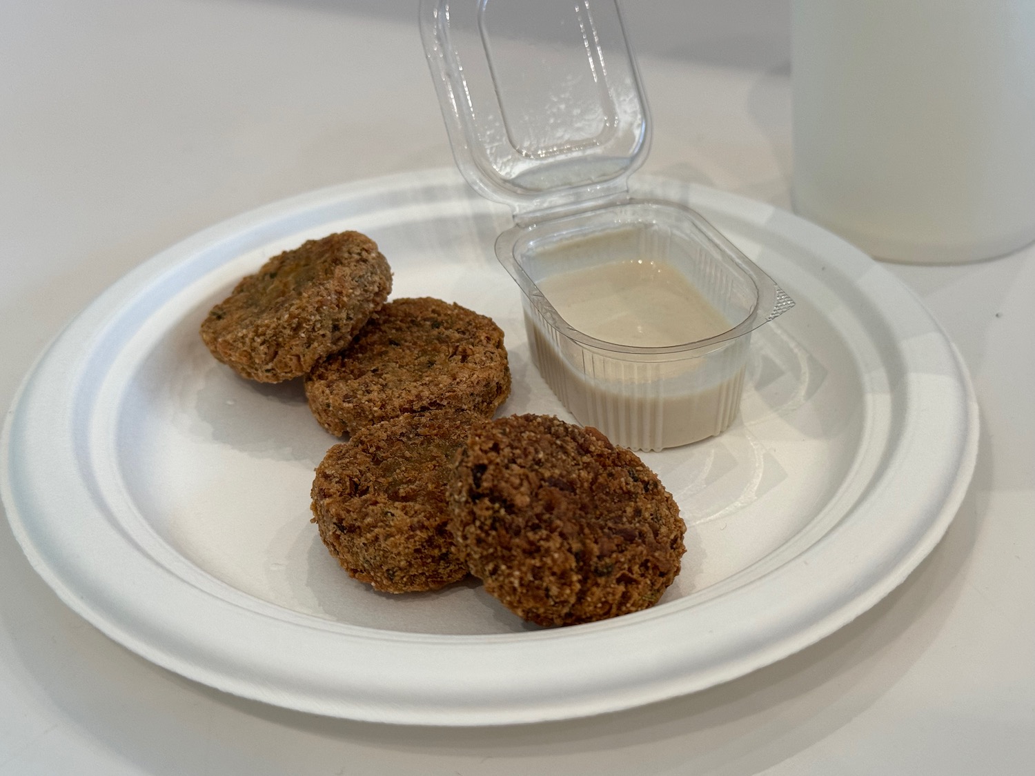 a plate of food with a container of sauce