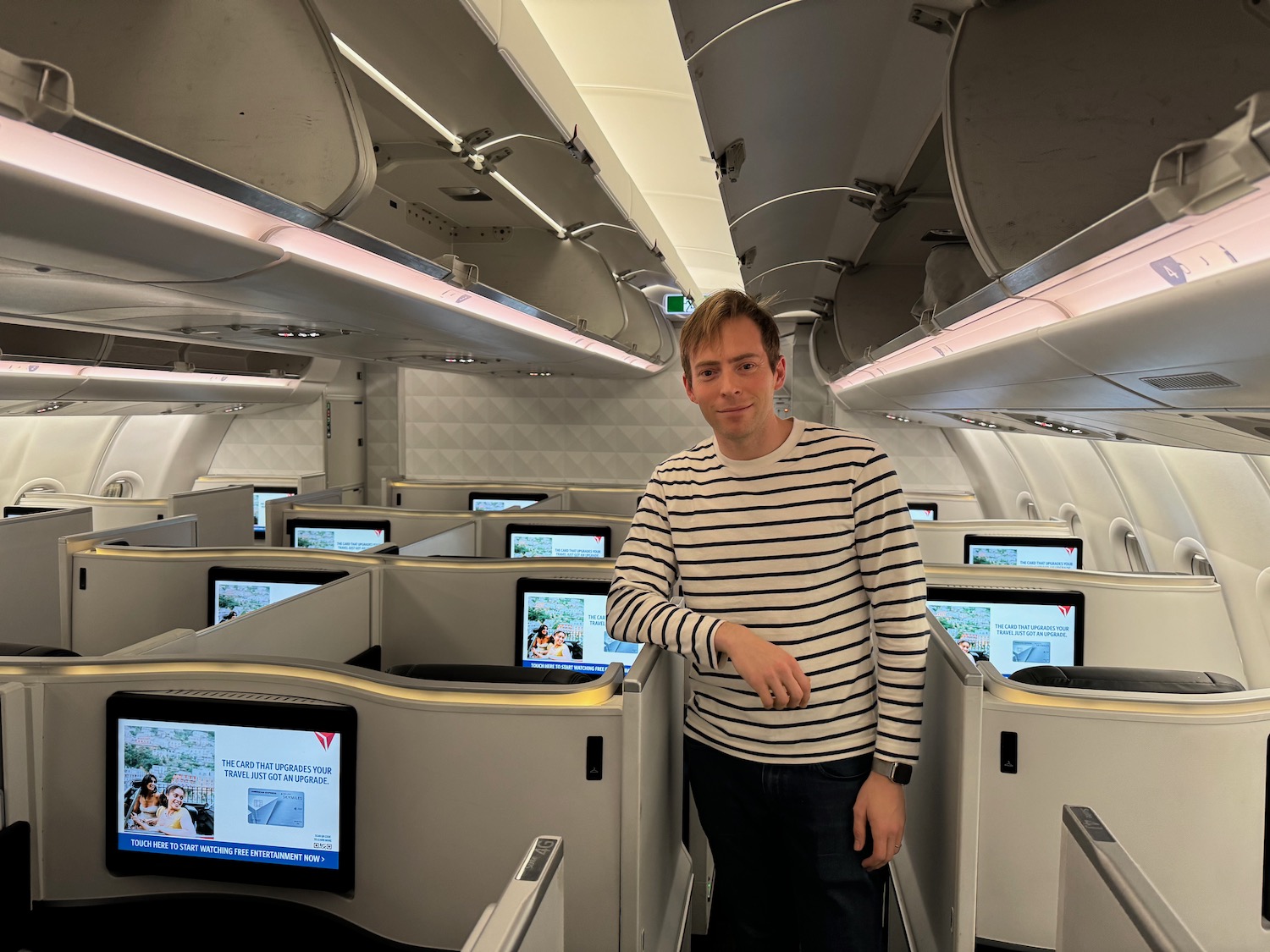 a man standing in an airplane with rows of screens
