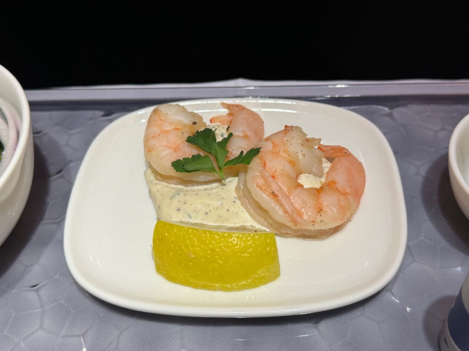 a plate of shrimp and lemon on a tray