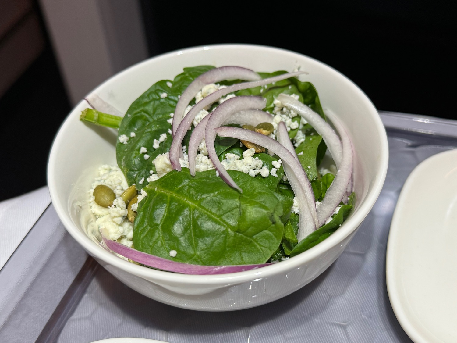 a bowl of salad with spinach and onions