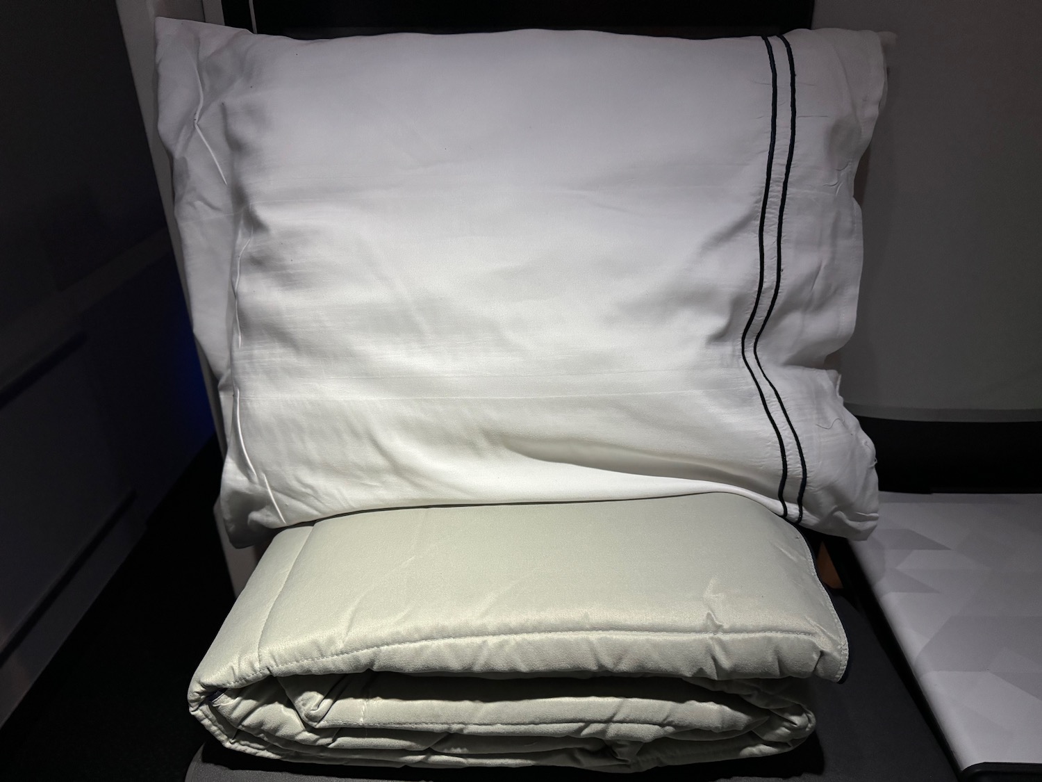 a white pillow and blanket on a bed