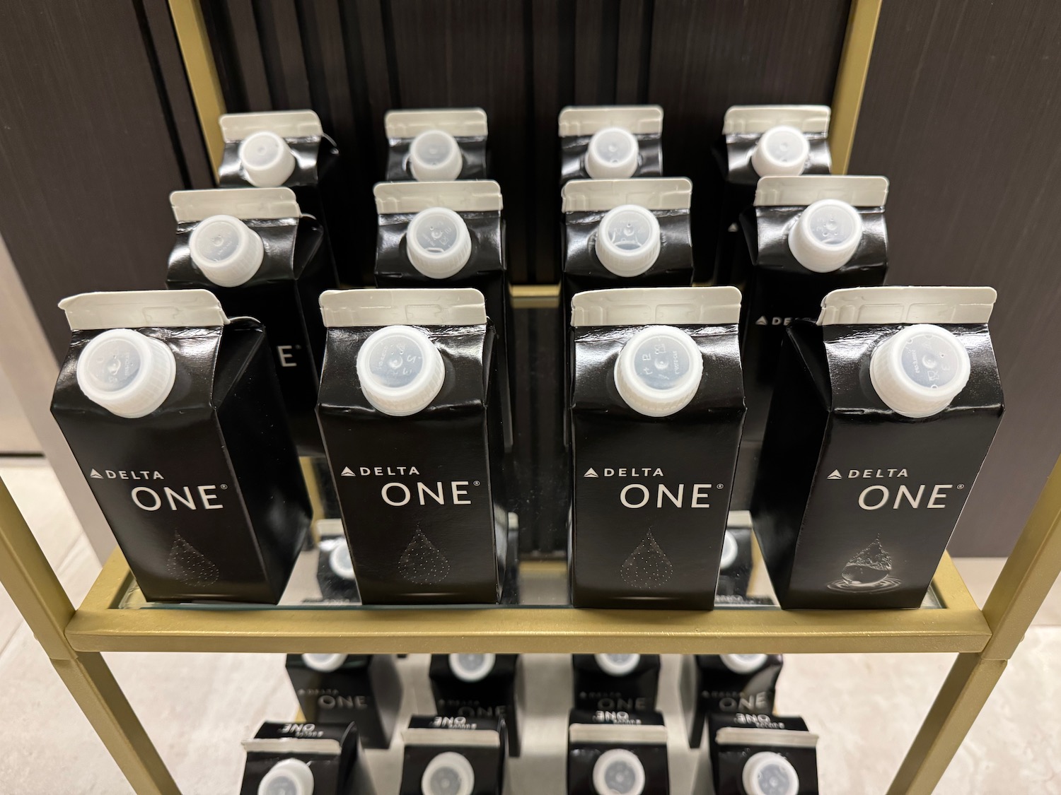 a group of black cartons with white caps on a shelf