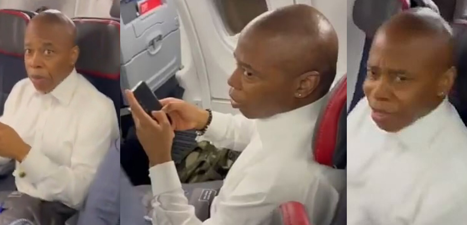 a man sitting in an airplane looking at his phone