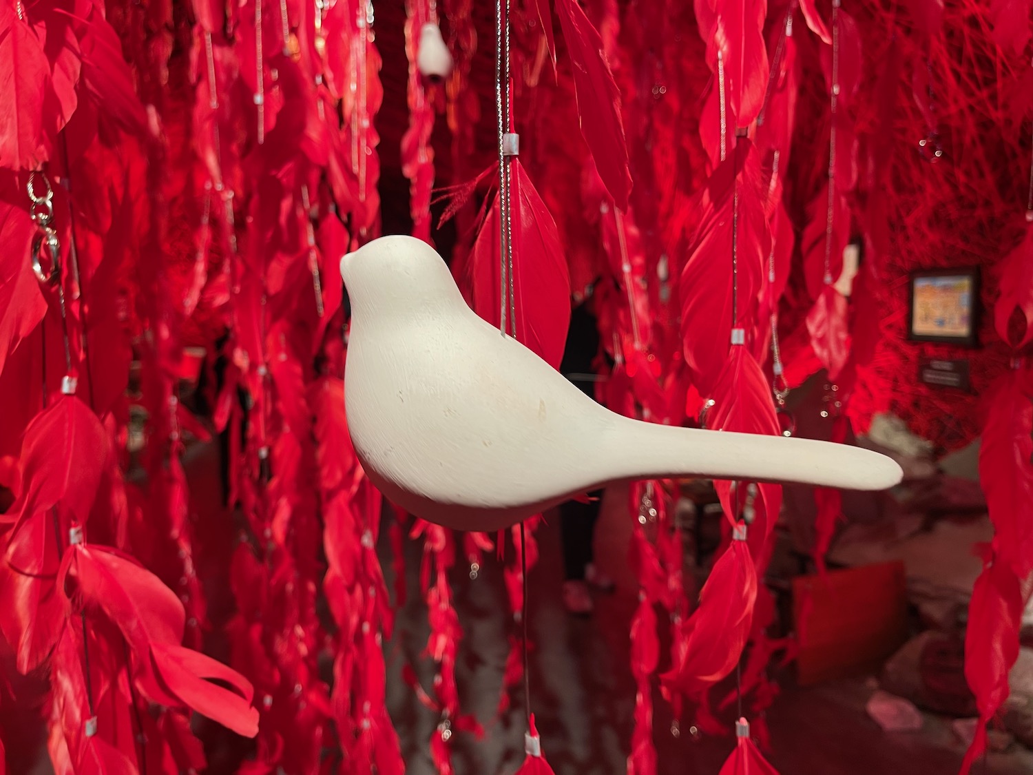 a white bird sculpture from red feathers