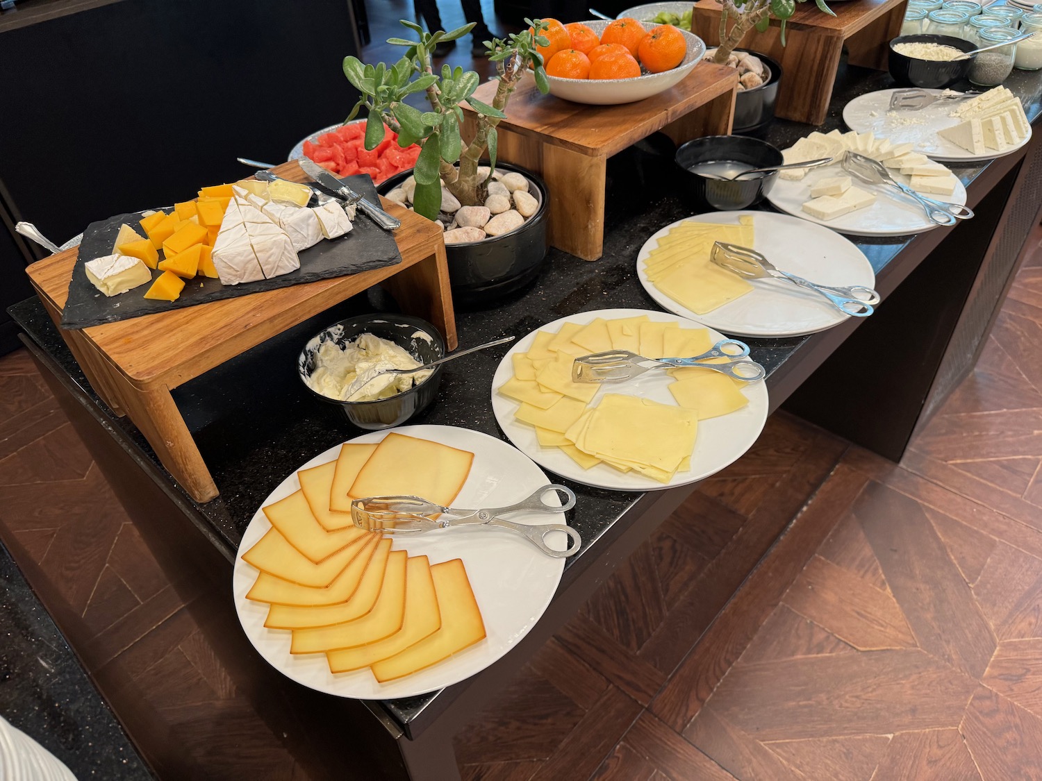 a table with plates of cheese and fruit