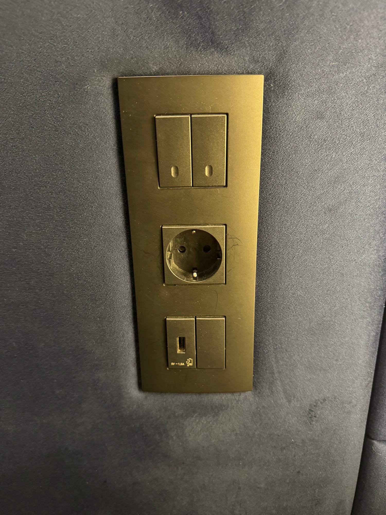 a gold rectangular outlet with two switches