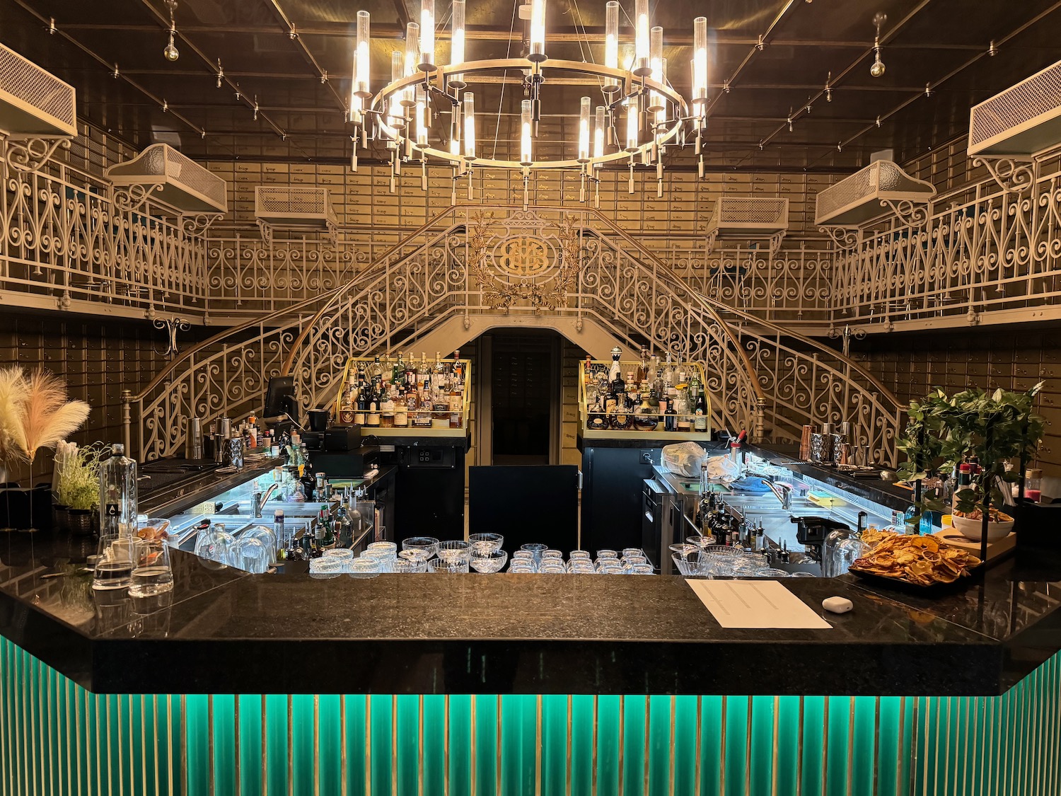 a bar with a chandelier and a staircase