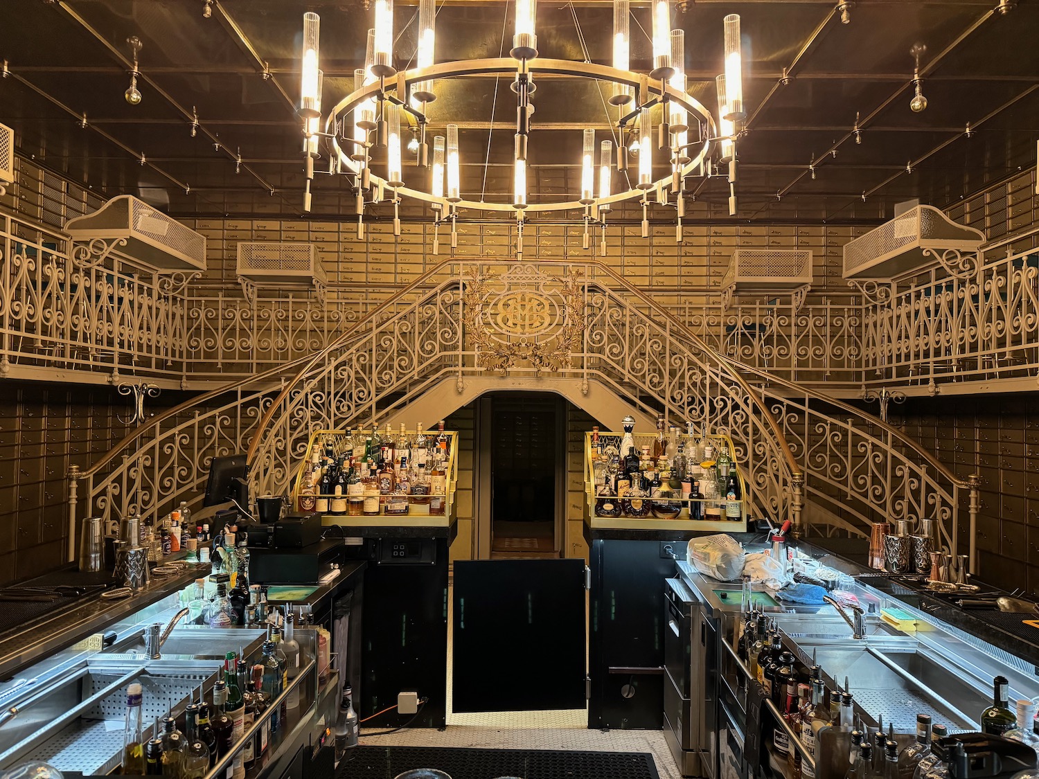 a bar with a chandelier and a staircase
