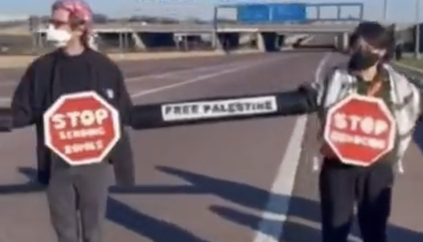 two men holding signs on a road
