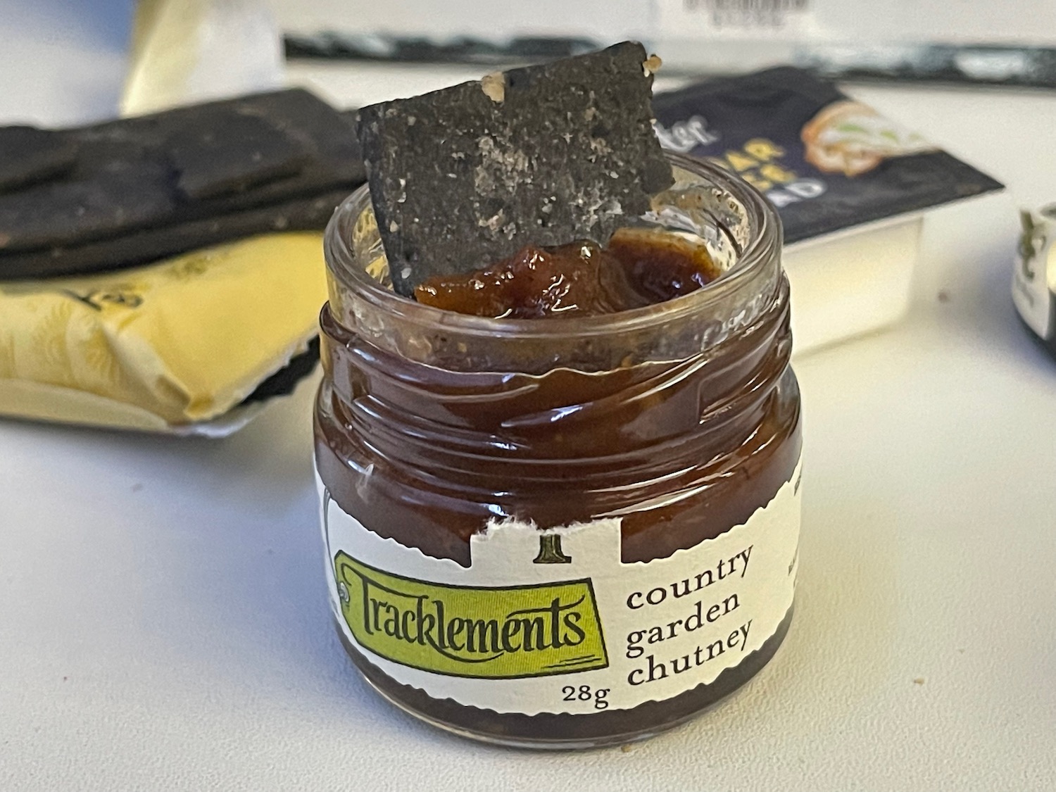 a jar of chutney with a cracker on top