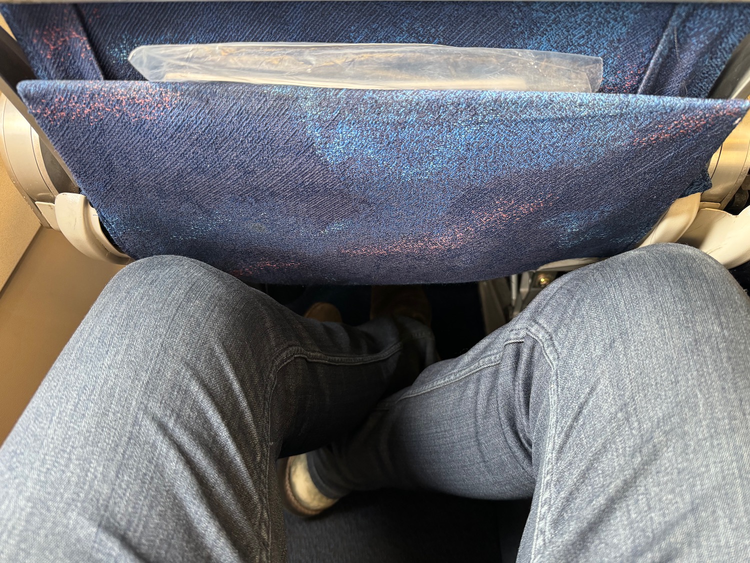 a person's legs in a blue seat