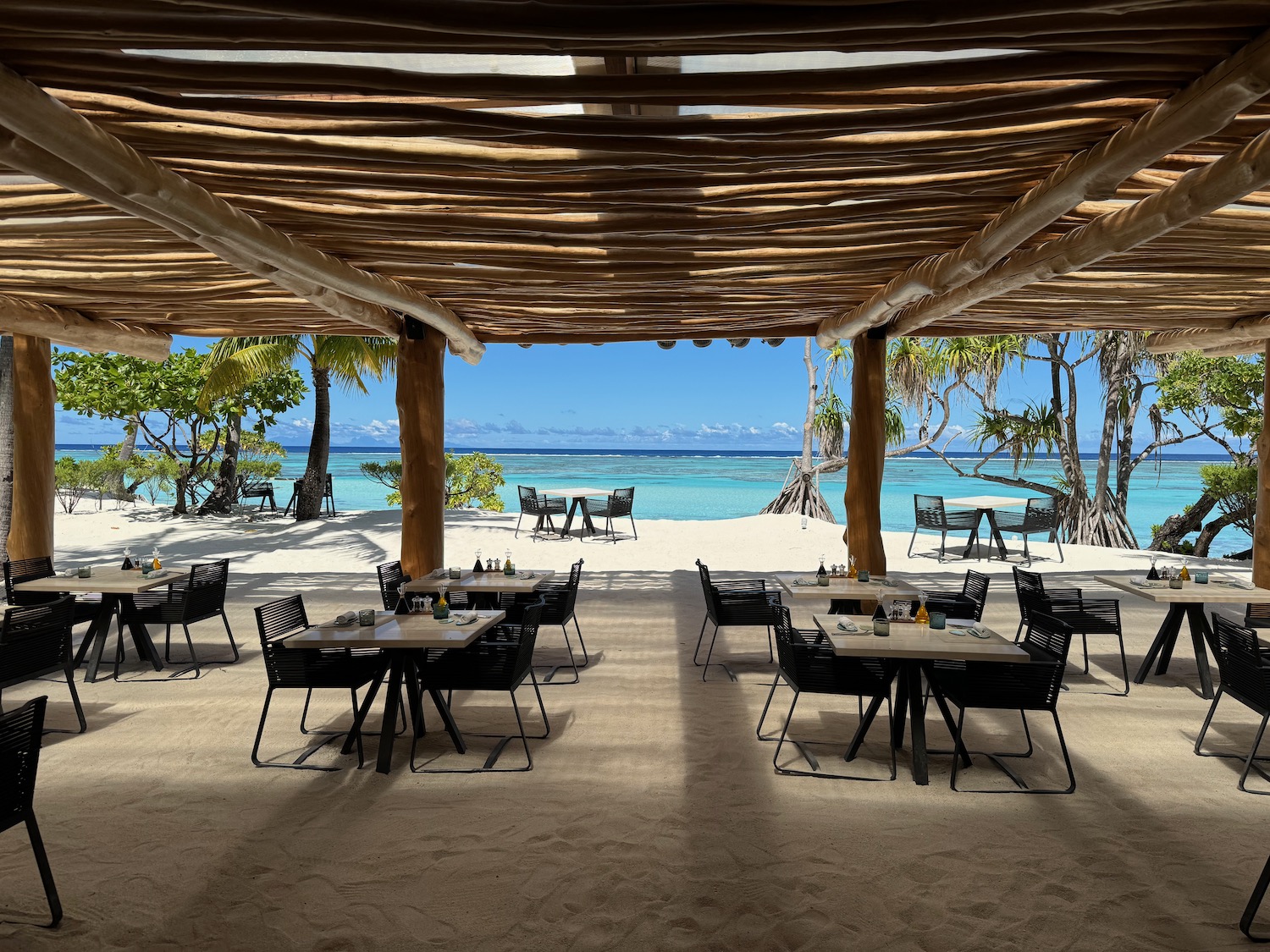 a beach restaurant with tables and chairs
