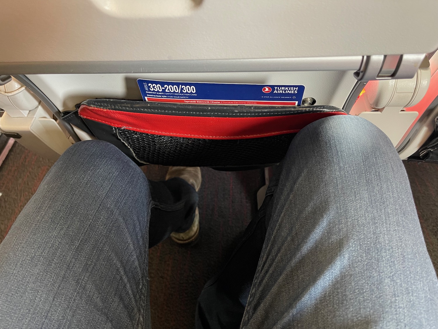 a person's legs and a pocket in a seat