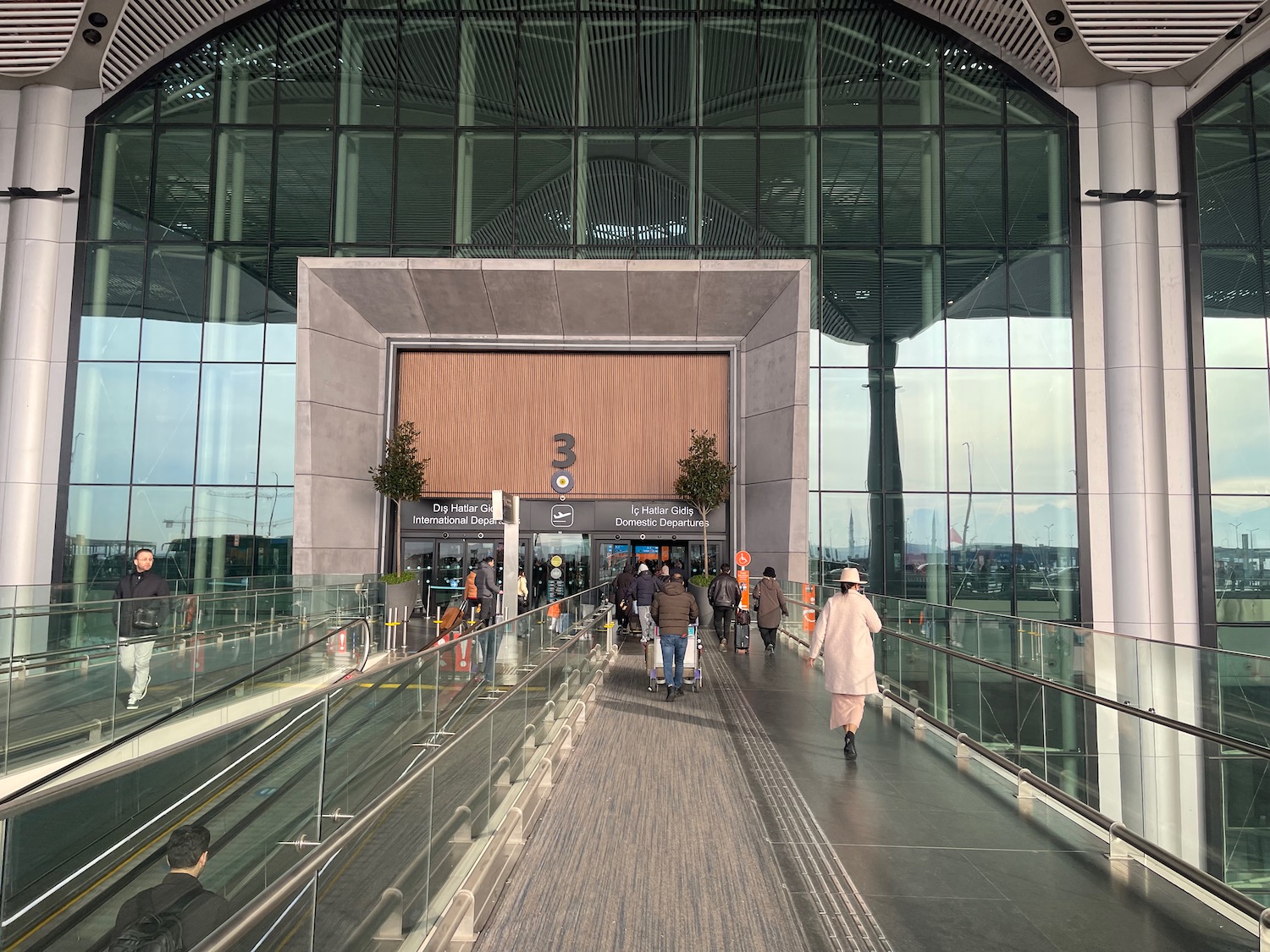 people walking down a walkway in a building