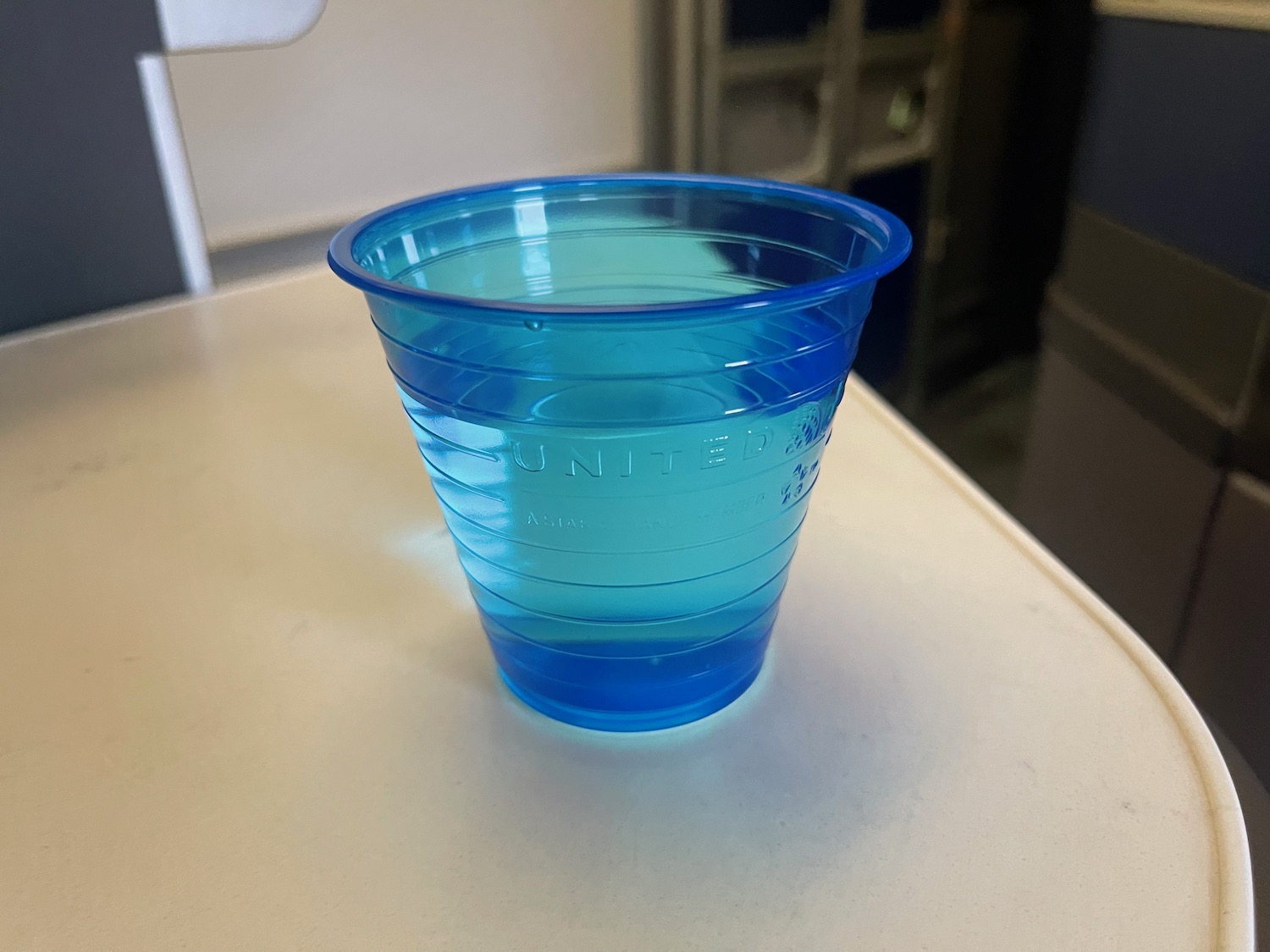 a blue plastic cup with liquid in it
