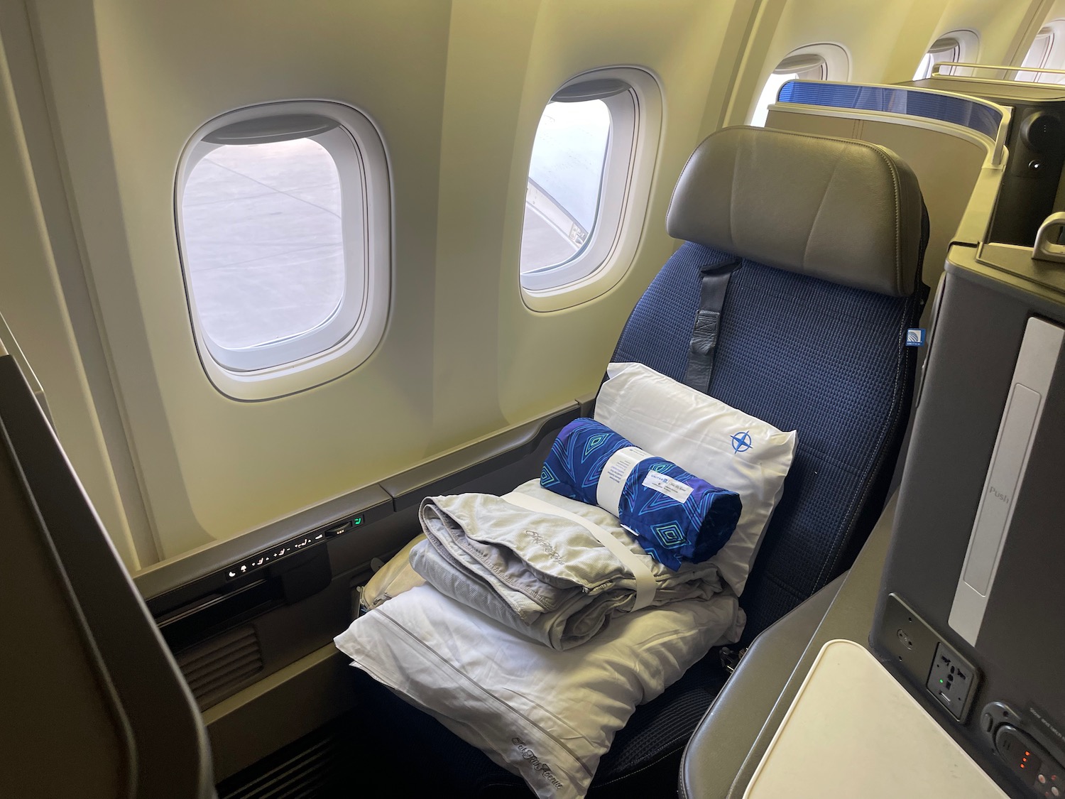 a seat with a pillow and blankets on it