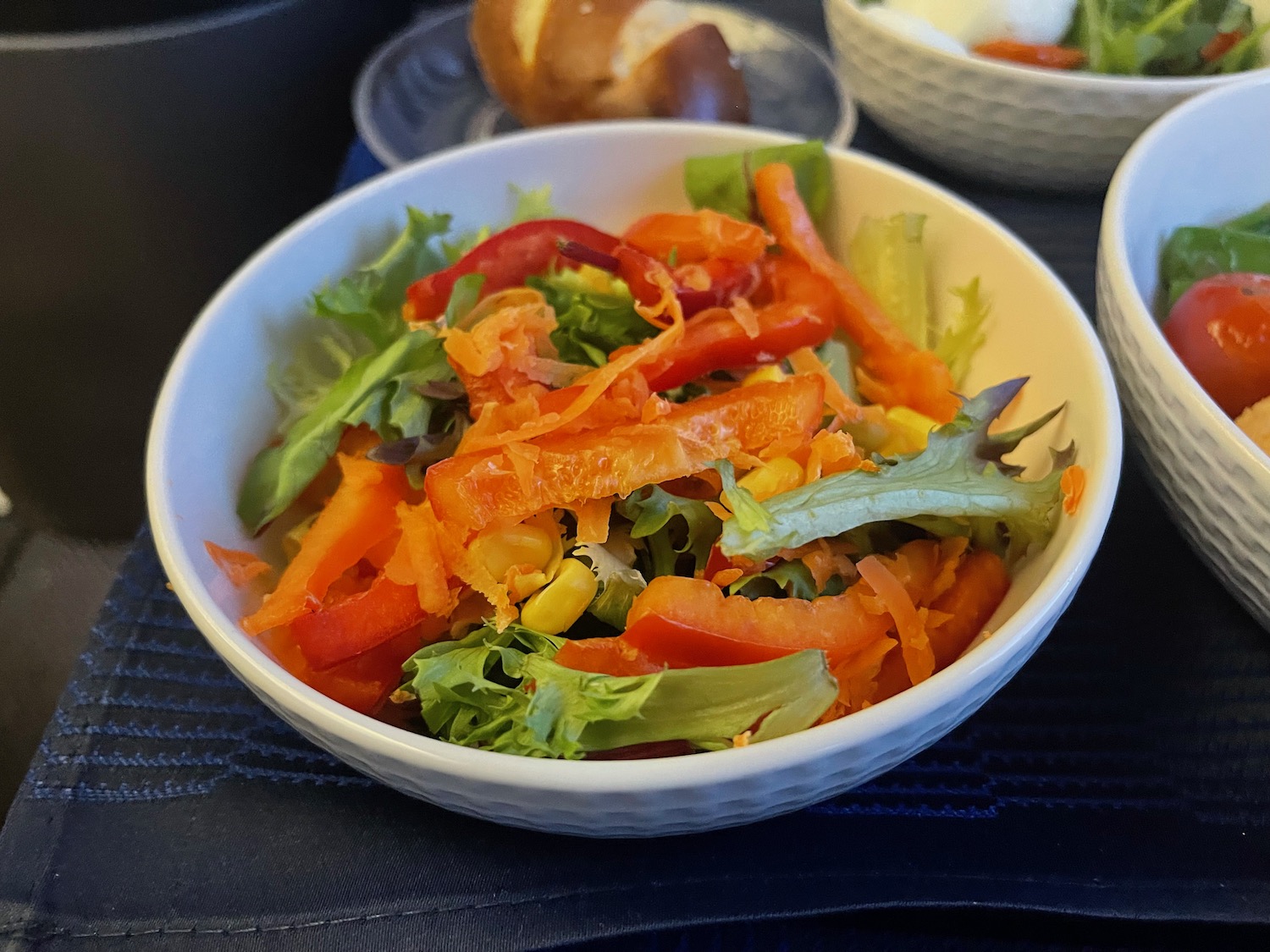 a bowl of salad with carrots and corn