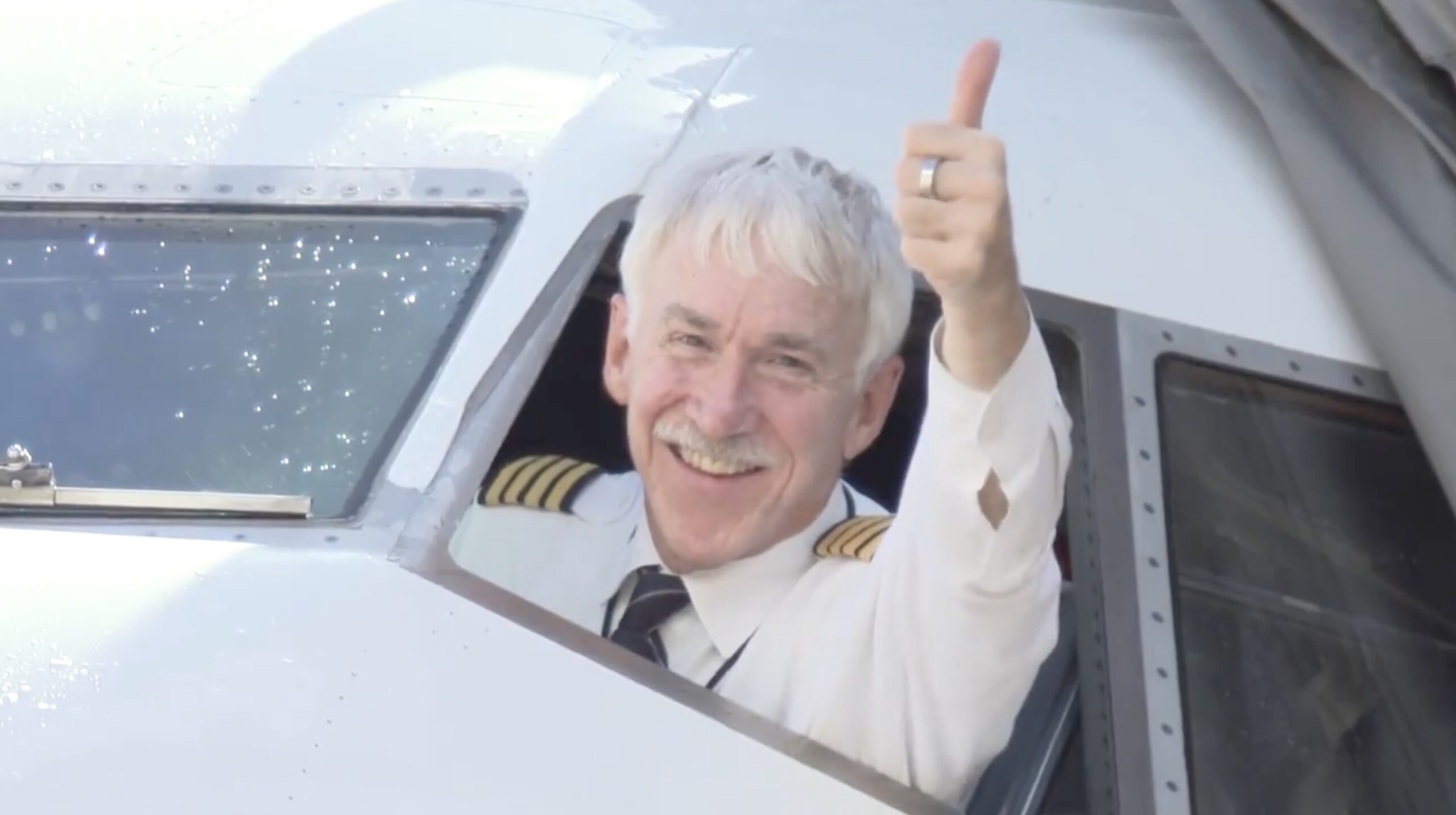 a man in uniform waving and smiling