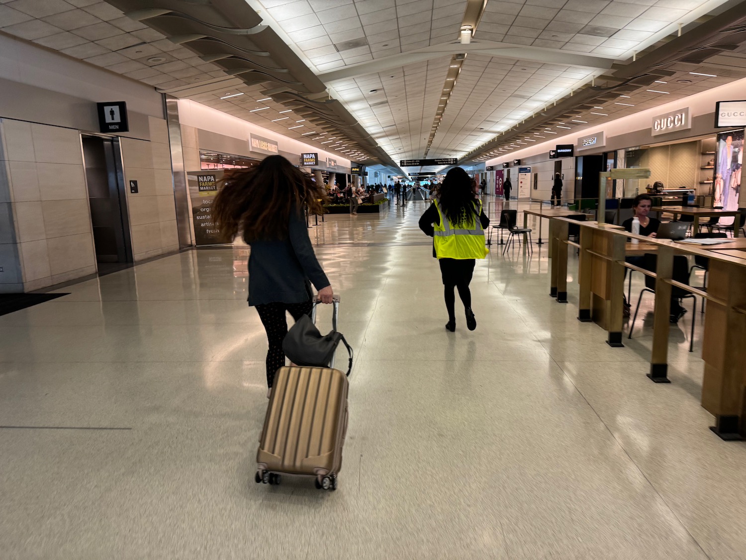 a woman pulling a suitcase in a airport