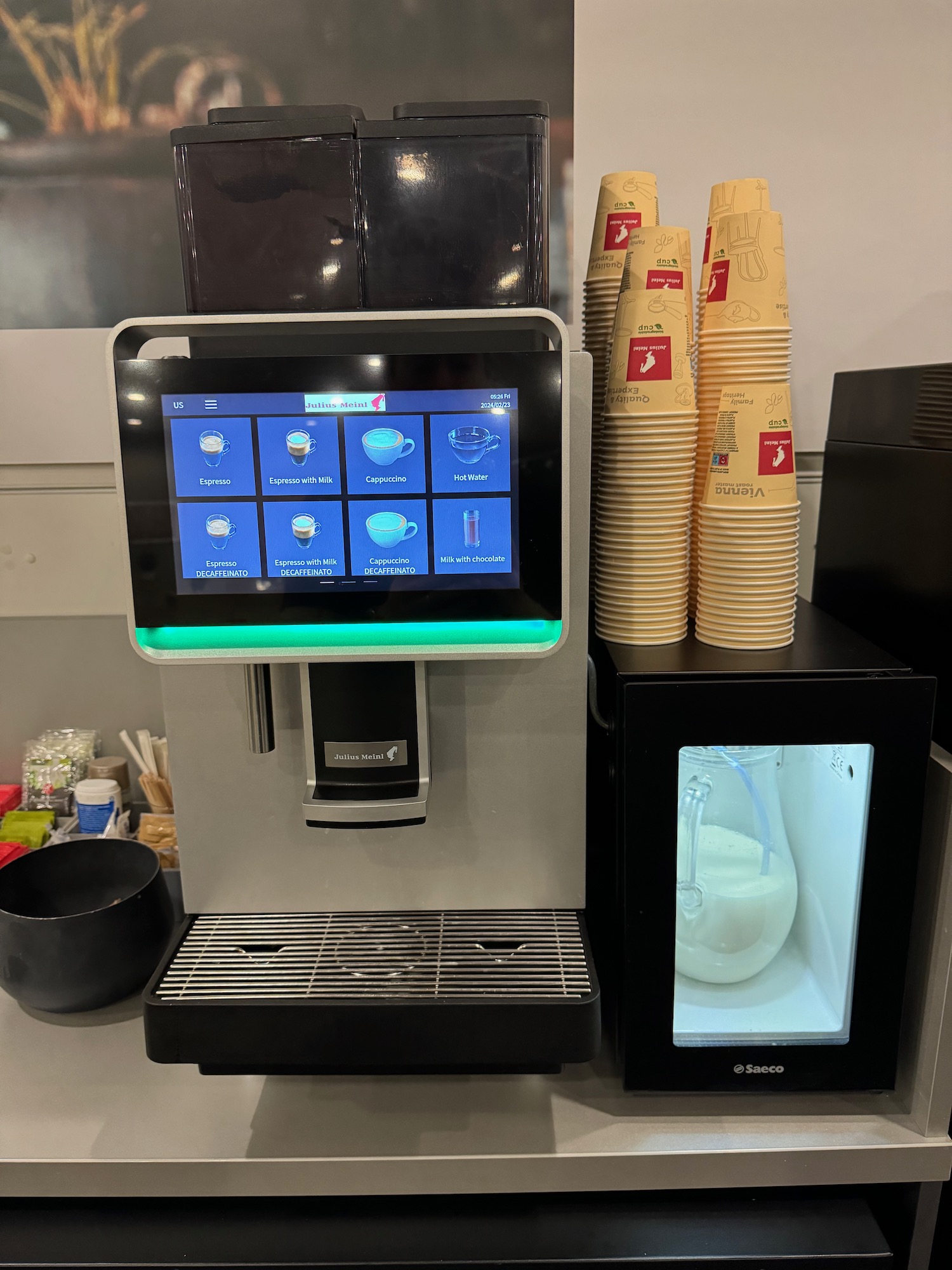 a machine with a screen and a stack of cups