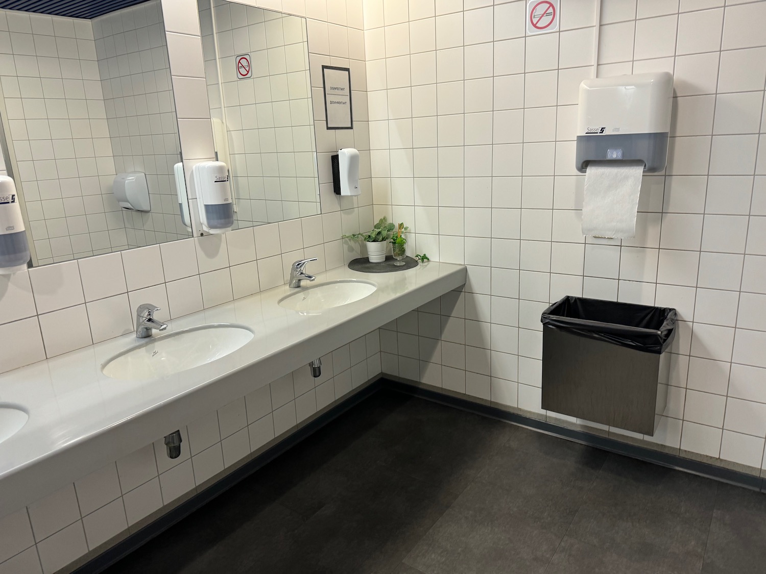 a bathroom with white tile walls and sinks