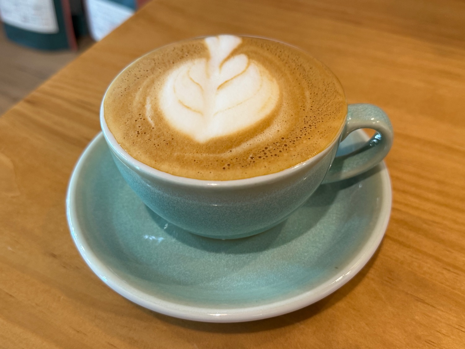 a cup of coffee with a leaf design in the foam