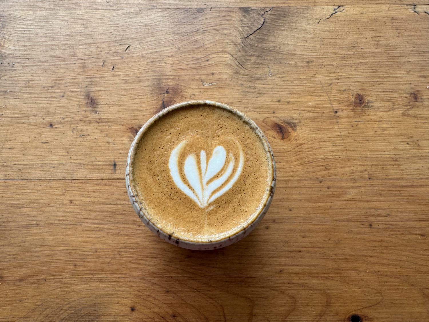 a cup of coffee with a heart design on top