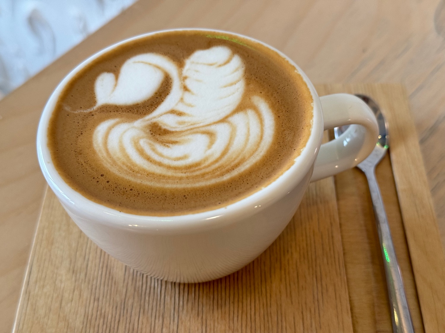 a cup of coffee with a swan design in the foam