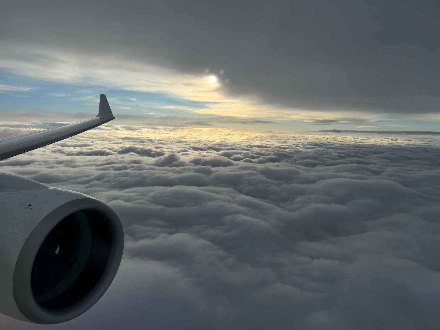 an airplane wing and engine above clouds