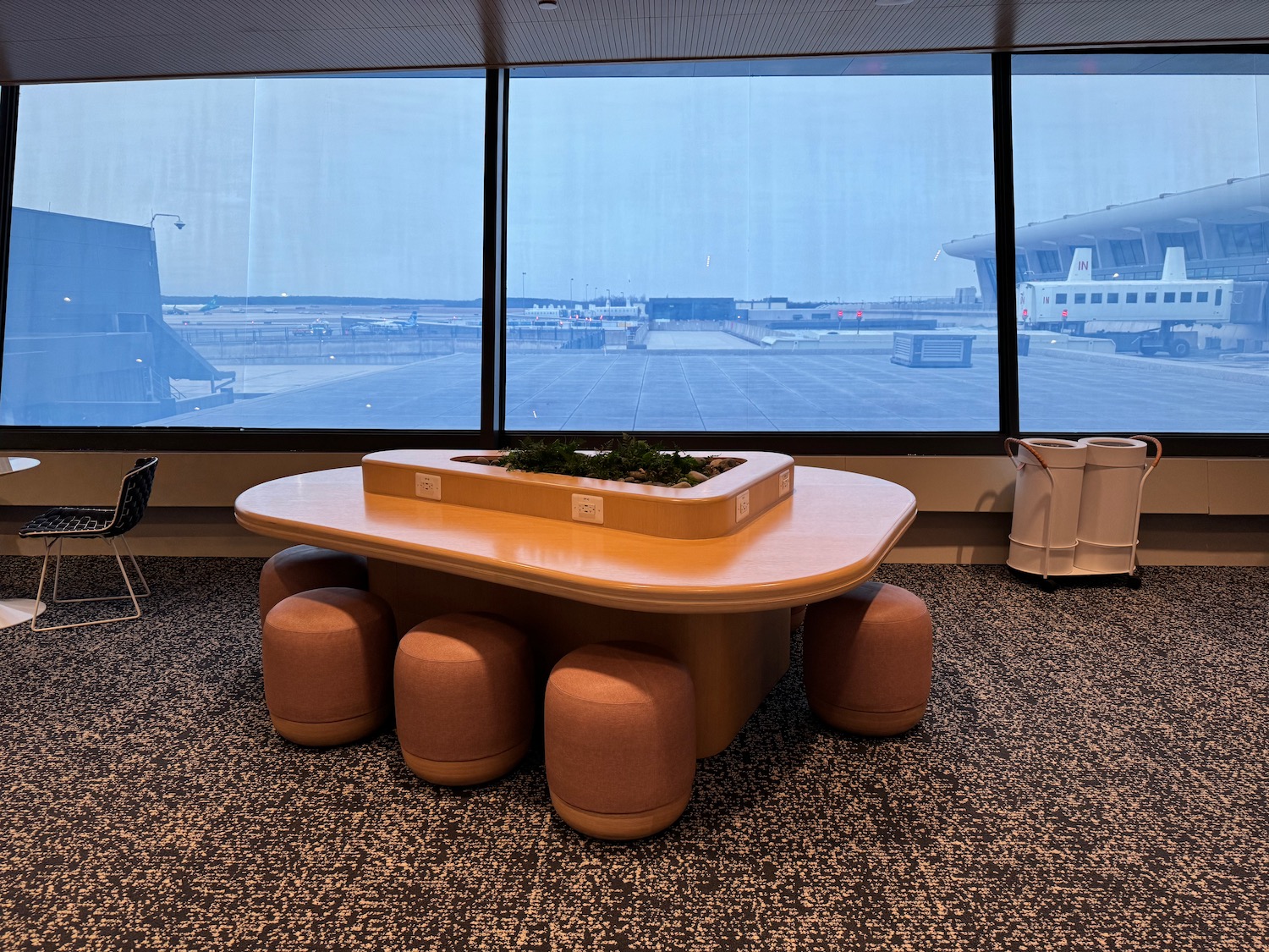 a table with stools in a room with windows