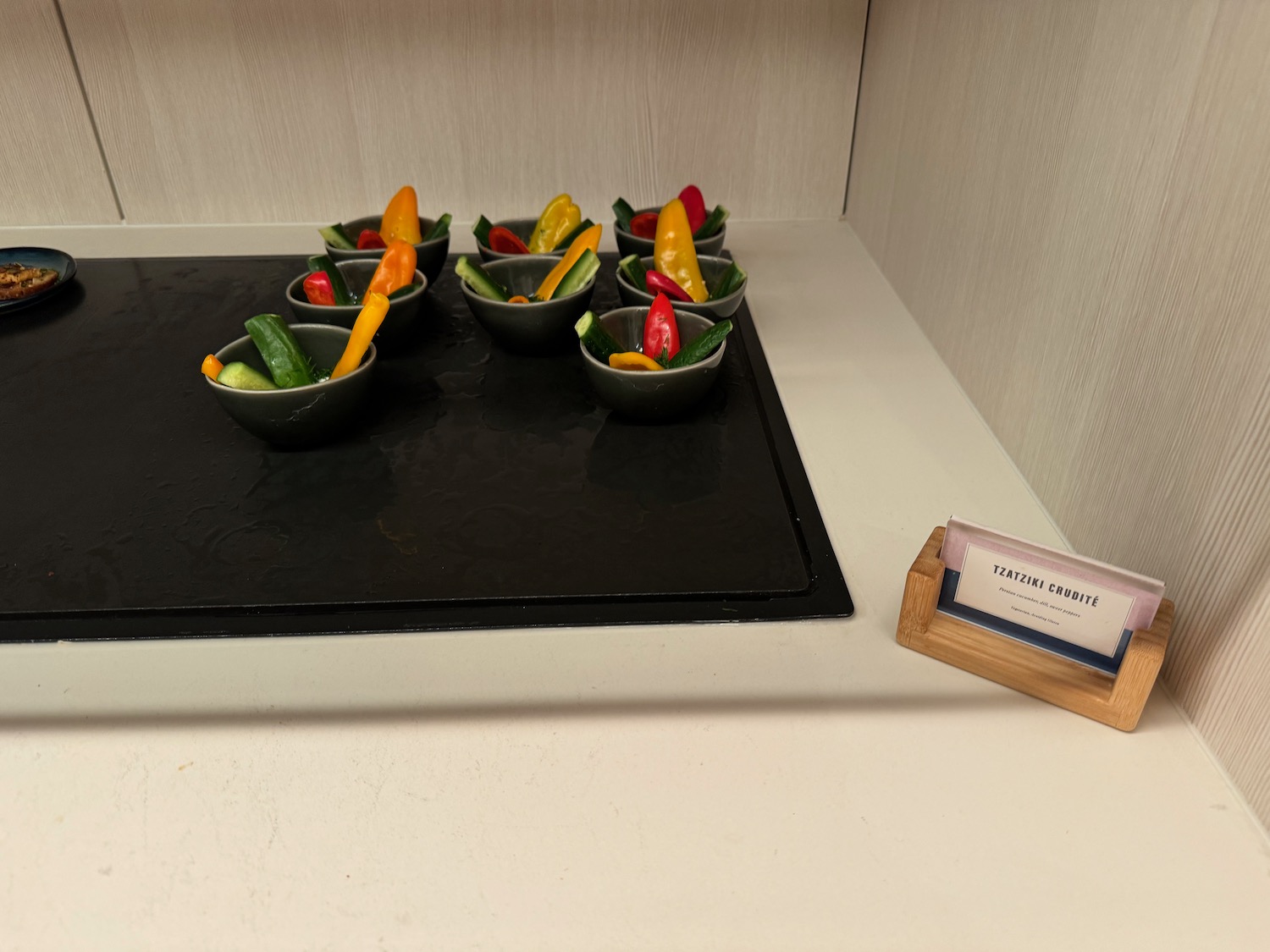 a group of small bowls of vegetables on a black surface