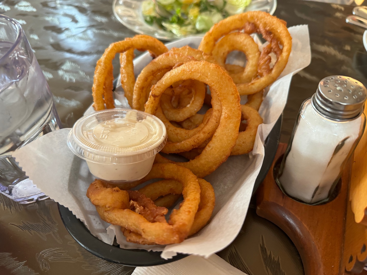 a plate of fried onion rings with sauce