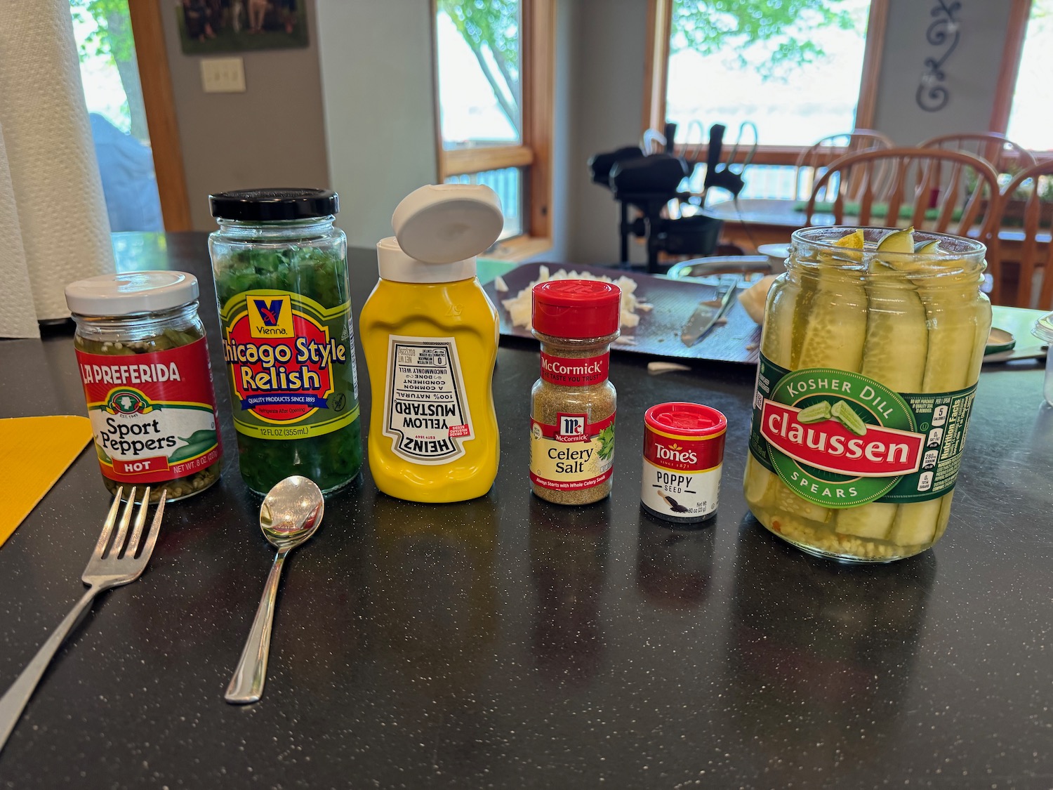 a group of jars of pickles and a spoon on a table