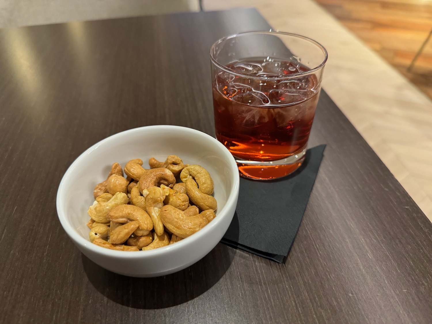 a bowl of cashews and a glass of liquid